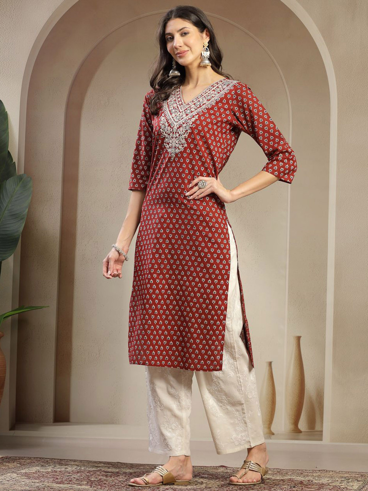 Aromie single piece kurta in red with white embroidery paired with cream pants, styled with earrings and sandals
