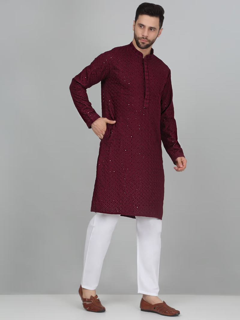 Male model wearing men's burgundy embroidered kurta set with mandarin collar subtle sequin embroidery and white pants