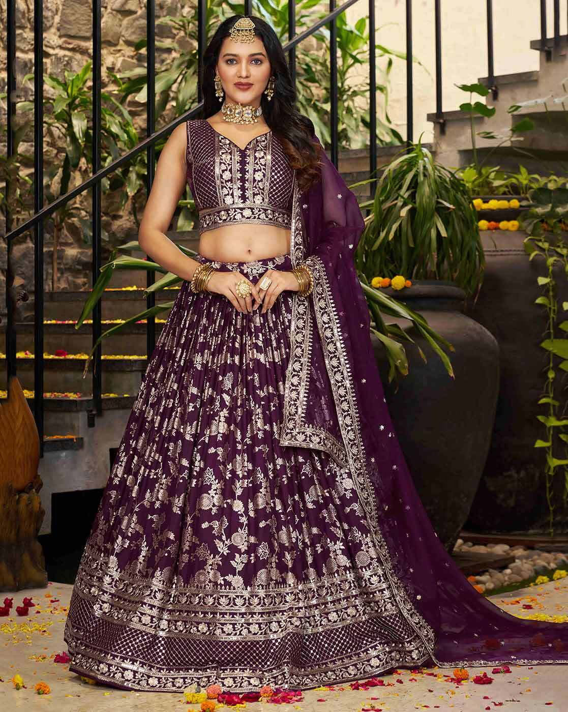 Model wearing a deep purple embroidered lehenga choli set Canada with silver floral embroidery, sleeveless blouse and dupatta