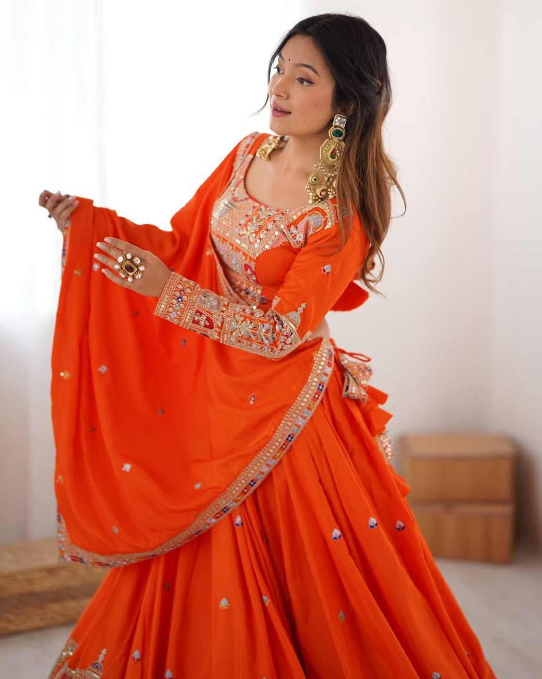 Woman in bright orange embroidered lehenga choli set Canada with detailed gold embroidery and matching dupatta