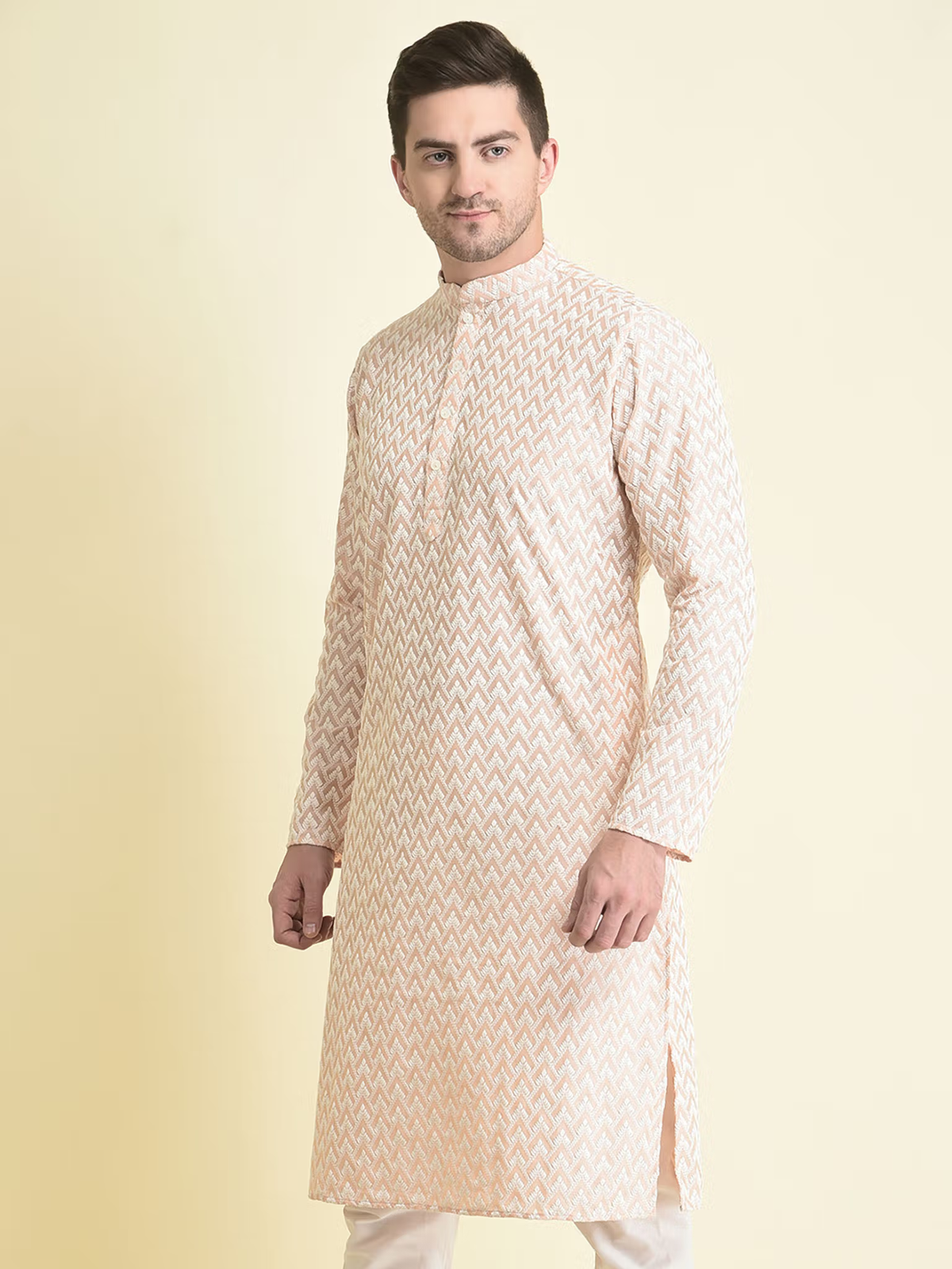men's pink chikankari kurta with subtle zigzag embroidery, mandarin collar, full sleeves and side slits, modeled for festive wear