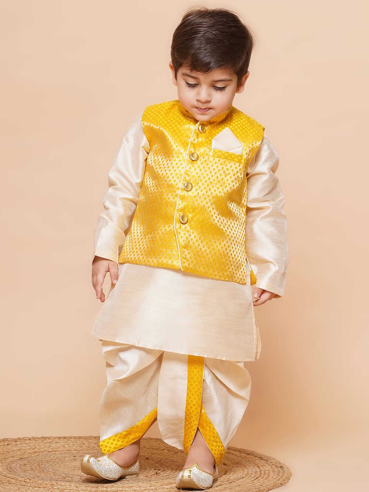 Young boy wearing boys yellow dhoti kurta set with waistcoat cream silk kurta and dhoti for festive occasions
