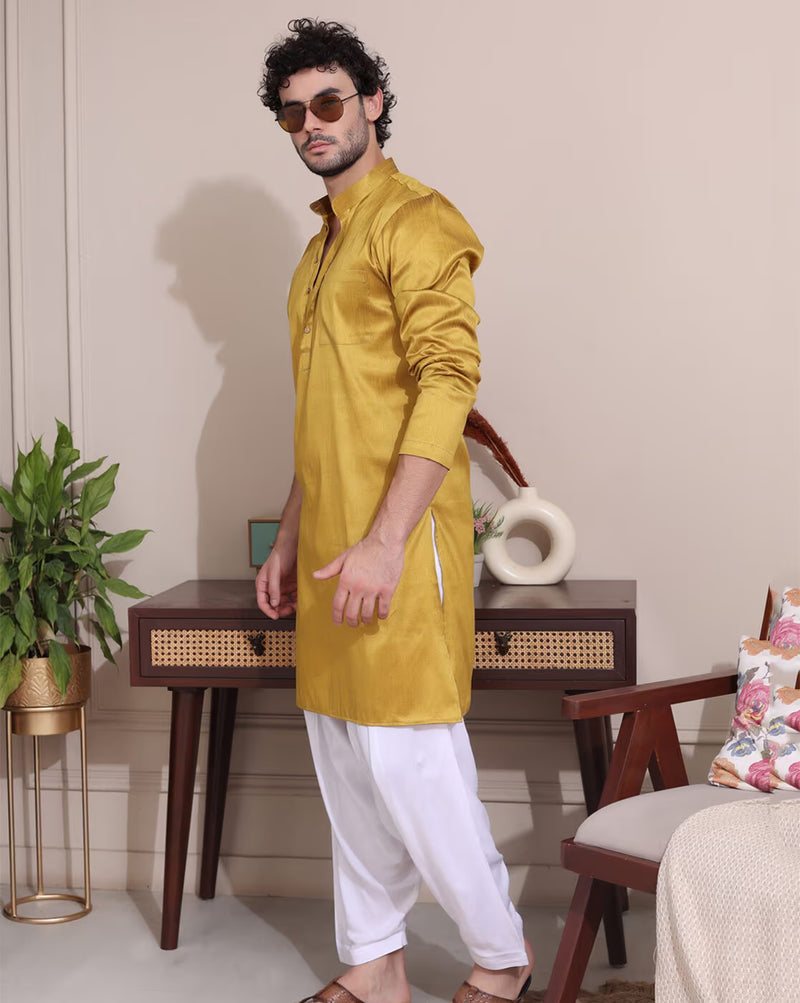Stylish men's mustard kurta Canada paired with white churidar and sunglasses for a trendy look