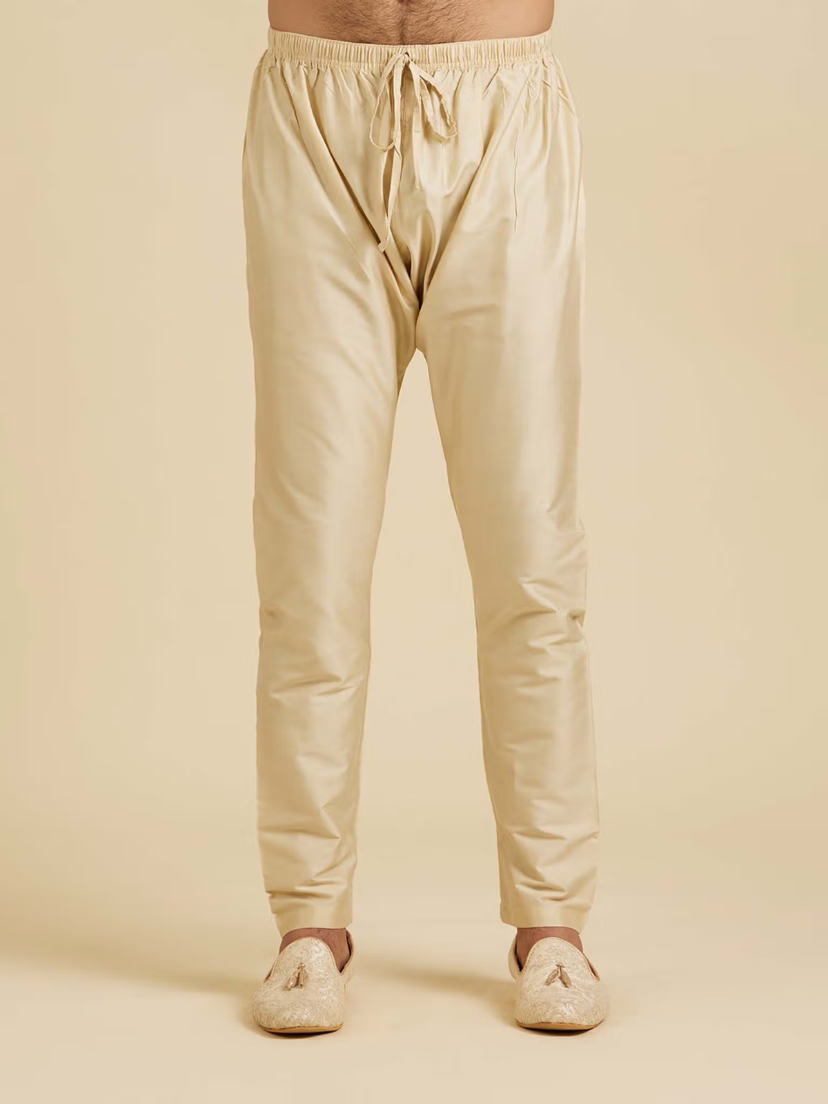 Beige drawstring pyjama pants photographed front view from blue floral kurta pyjama set by AROMIE