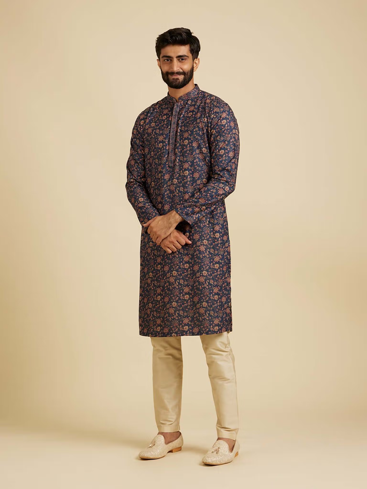 Male model wearing blue floral kurta pyjama set with beige pyjama pants and traditional loafers