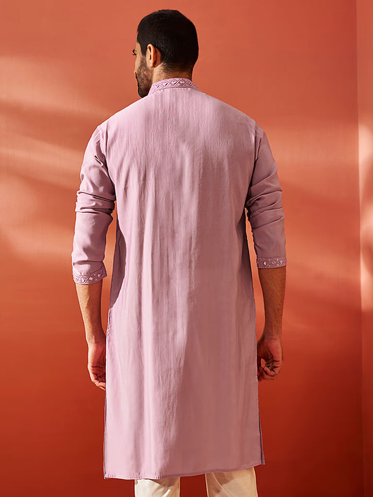 Back view of mens chanderi silk kurta in dusty pink with mandarin collar and embroidered cuffs on model