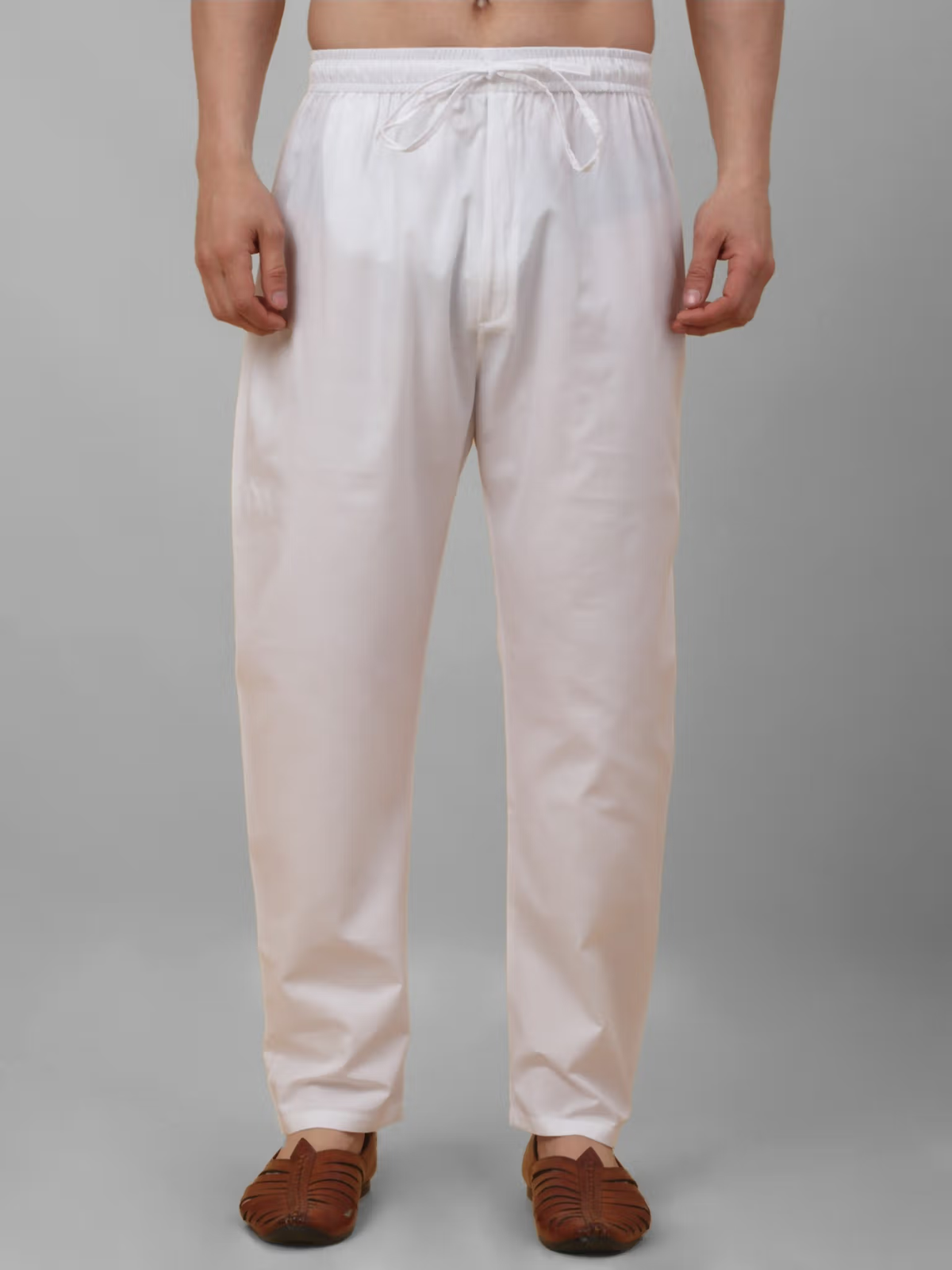 White cotton pajama pants shown on model from men's black kurta pajama nehru jacket set by AROMIE