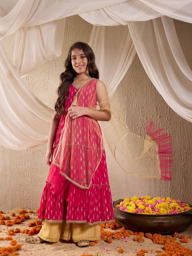 Young woman in pink printed Indian kurta palazzo dupatta set Canada with gold palazzo and sheer dupatta over marigold decor