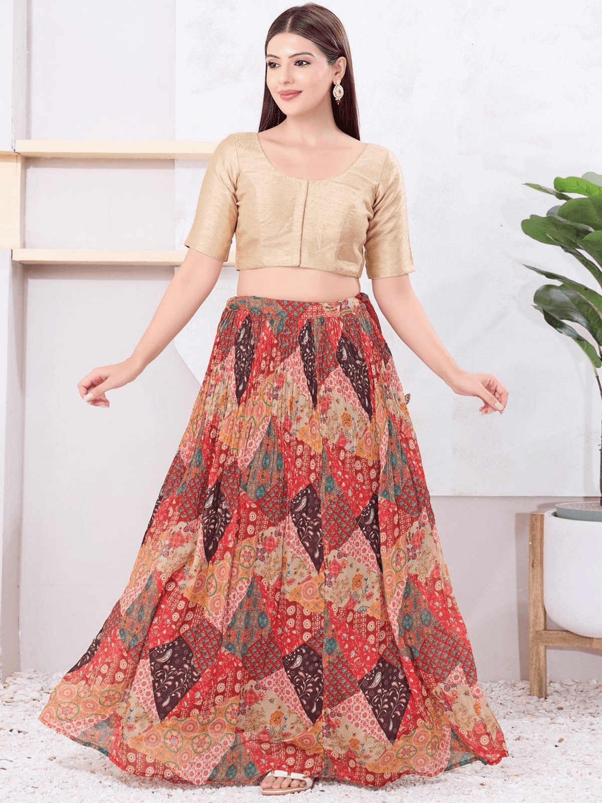 Woman wearing a gold blouse and colorful patterned skirt in a minimalistic setting.