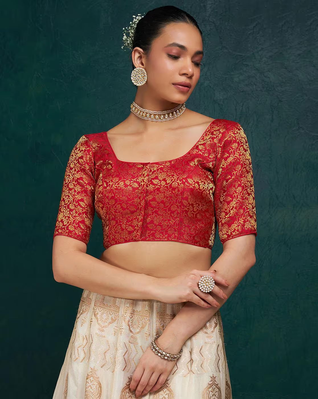 Woman wearing a red and gold traditional outfit with a dark green background