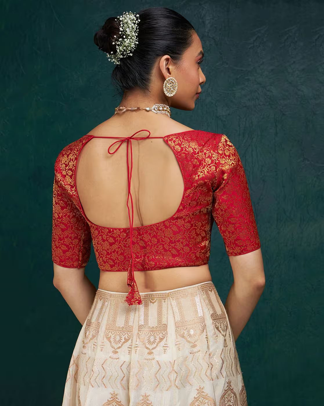 Woman wearing a red embroidered blouse with a green background