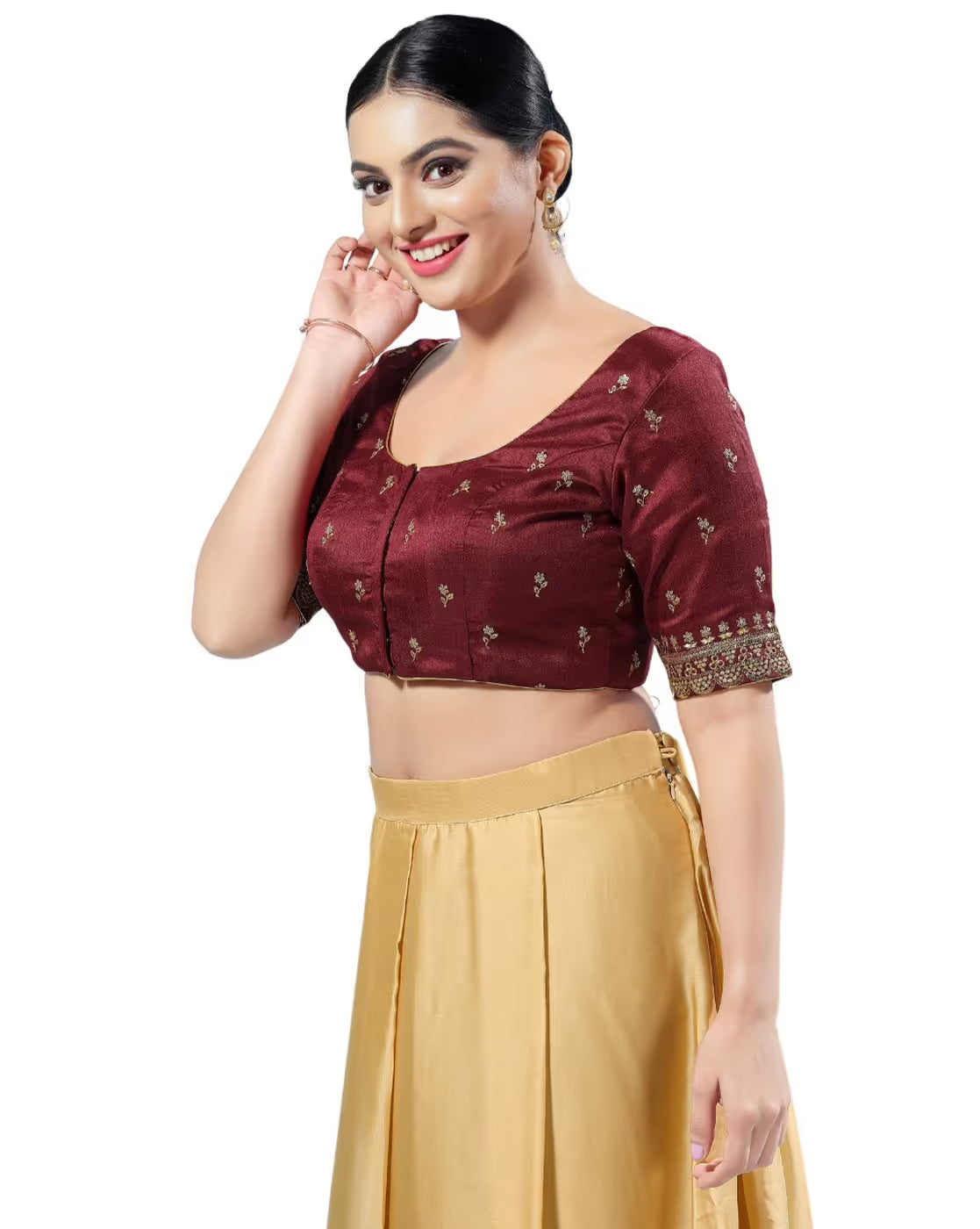 Woman wearing a maroon blouse with gold patterns and a beige skirt on a white background