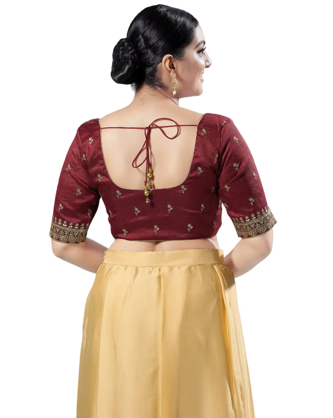 Woman wearing a maroon blouse with gold detailing and a yellow skirt on a white background