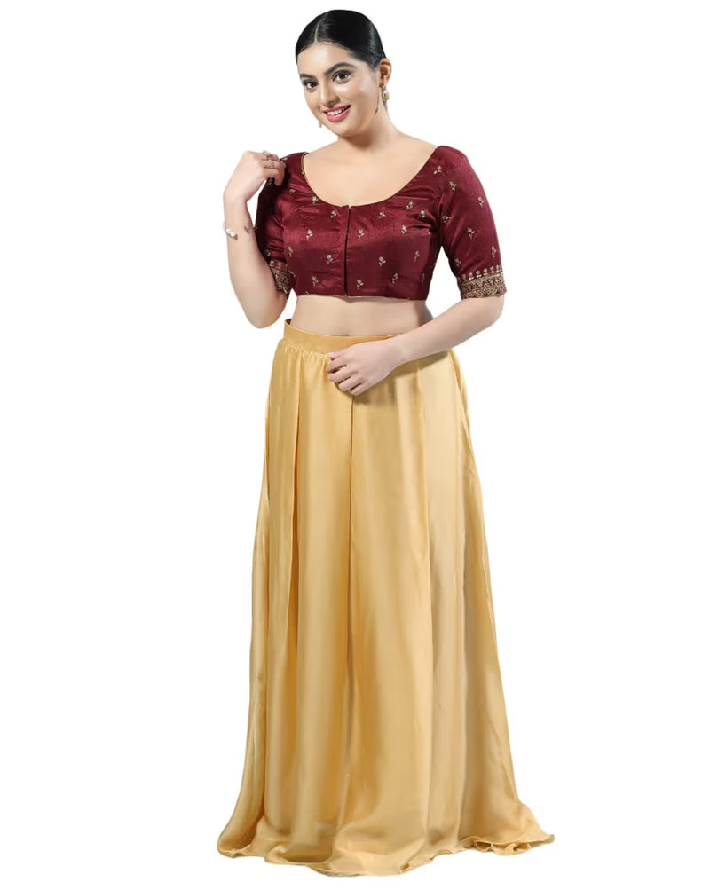 Woman wearing a maroon blouse with gold skirt on a white background