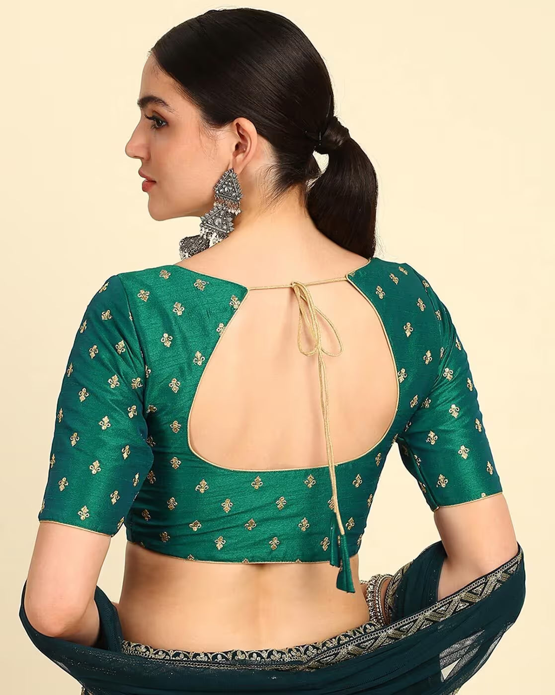Woman wearing a green blouse with floral patterns on a beige background