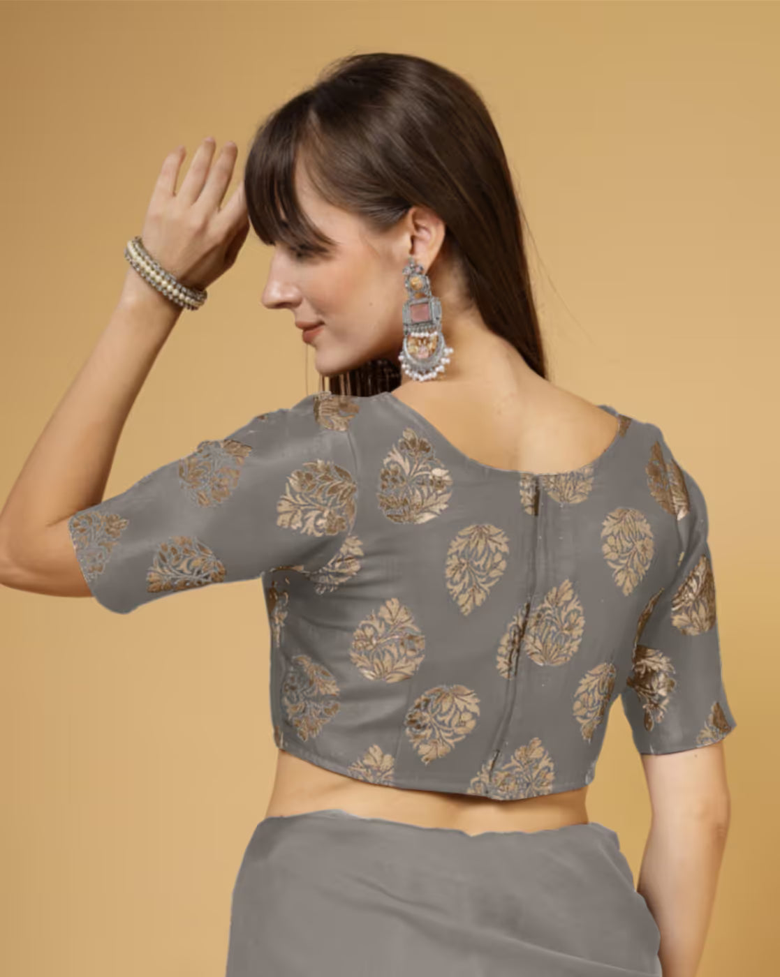 Woman wearing a gray blouse with floral patterns on a beige background