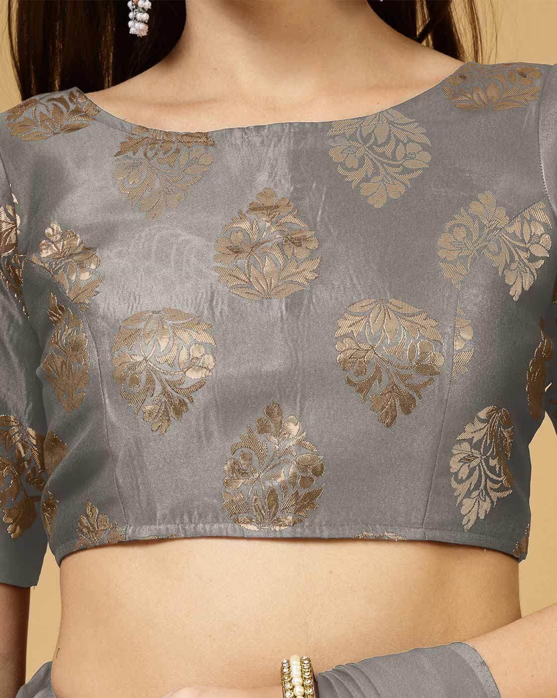 Gray blouse with gold floral patterns on a beige background