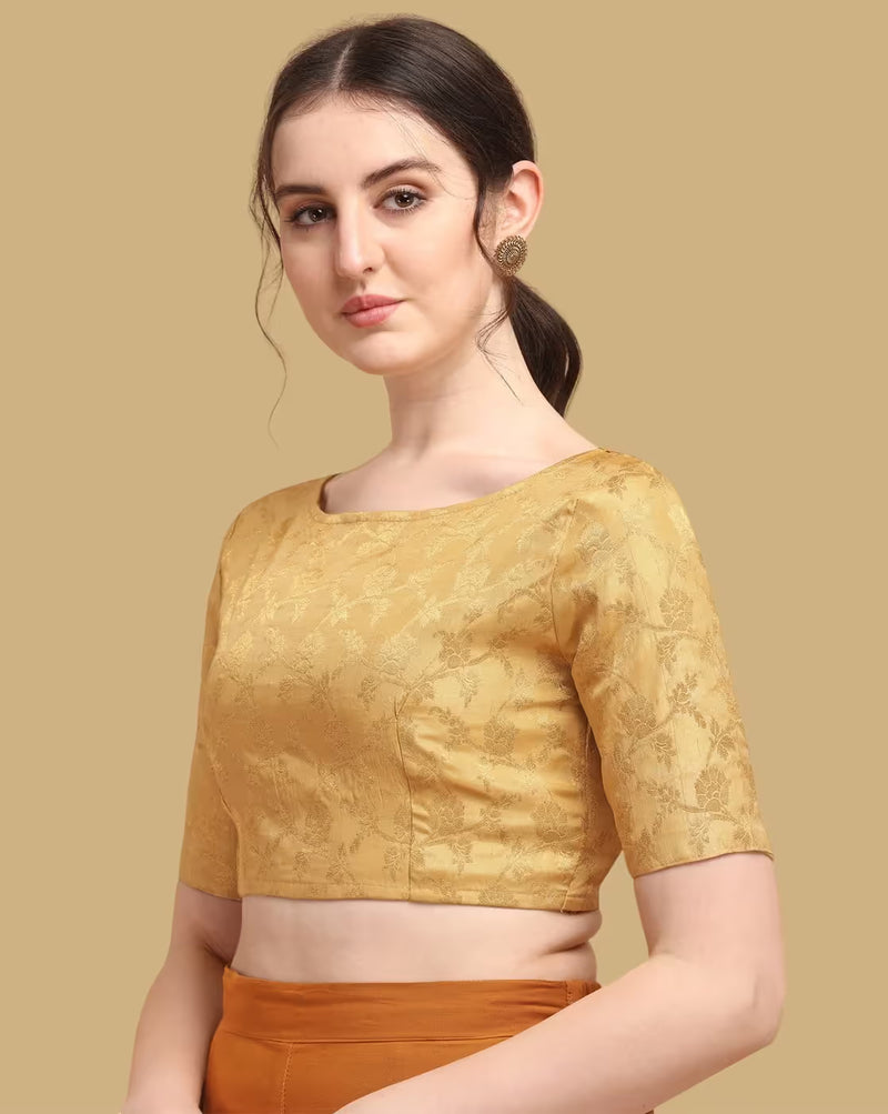 Woman wearing a mustard yellow blouse with a subtle pattern on a beige background