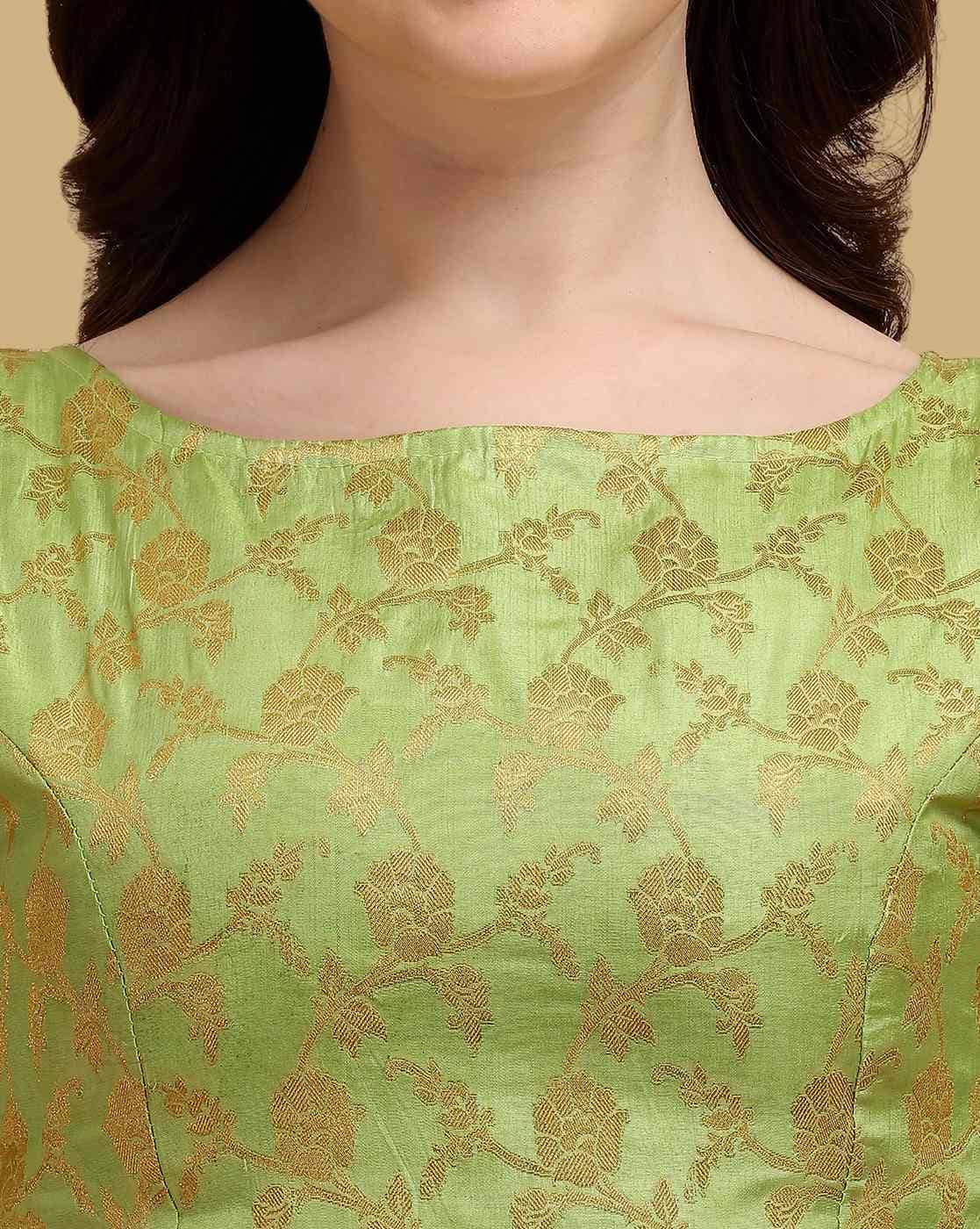 Green fabric with gold floral patterns worn by a person