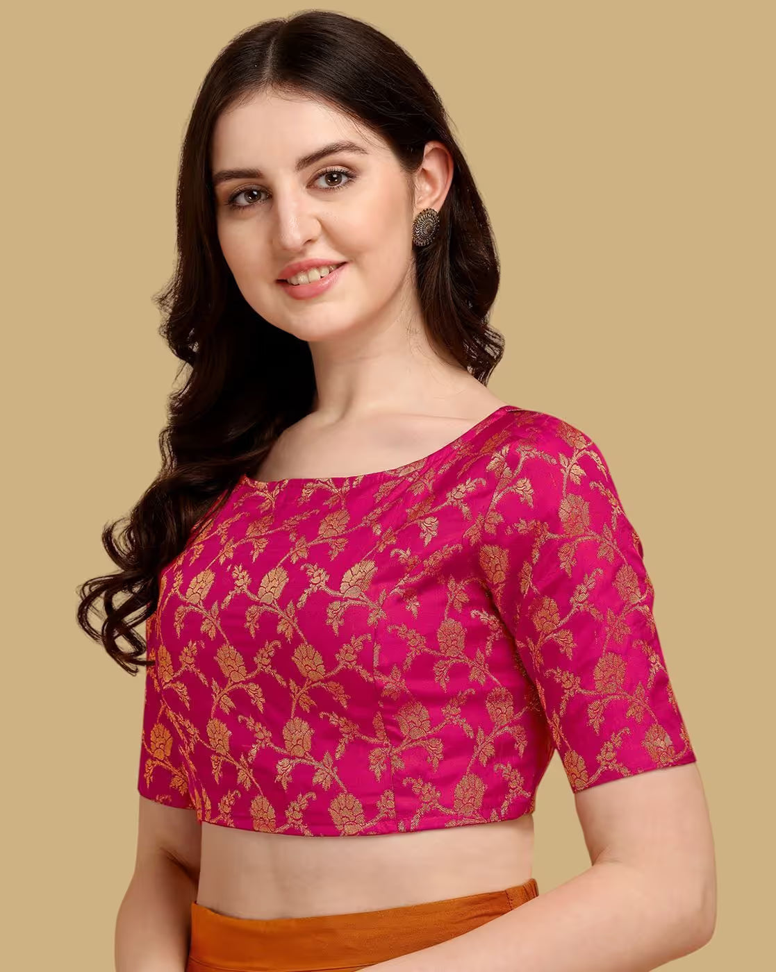 Woman wearing a pink blouse with gold patterns on a beige background