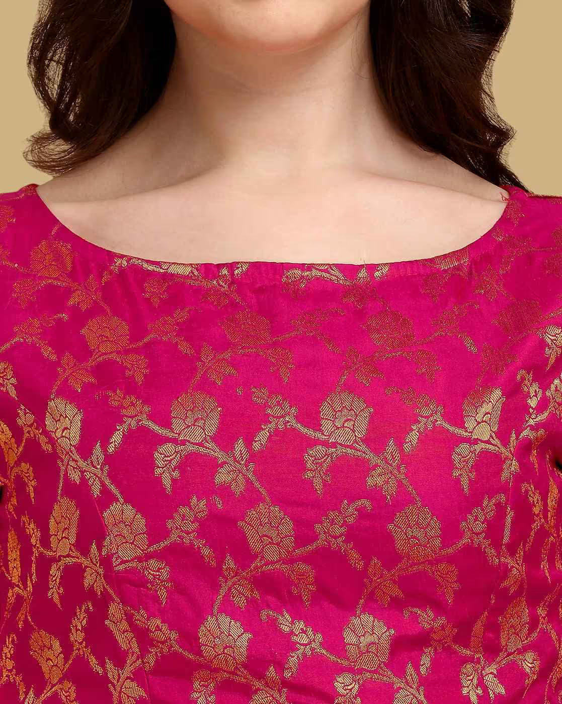 Close-up of a pink fabric with gold floral patterns, worn by a person.