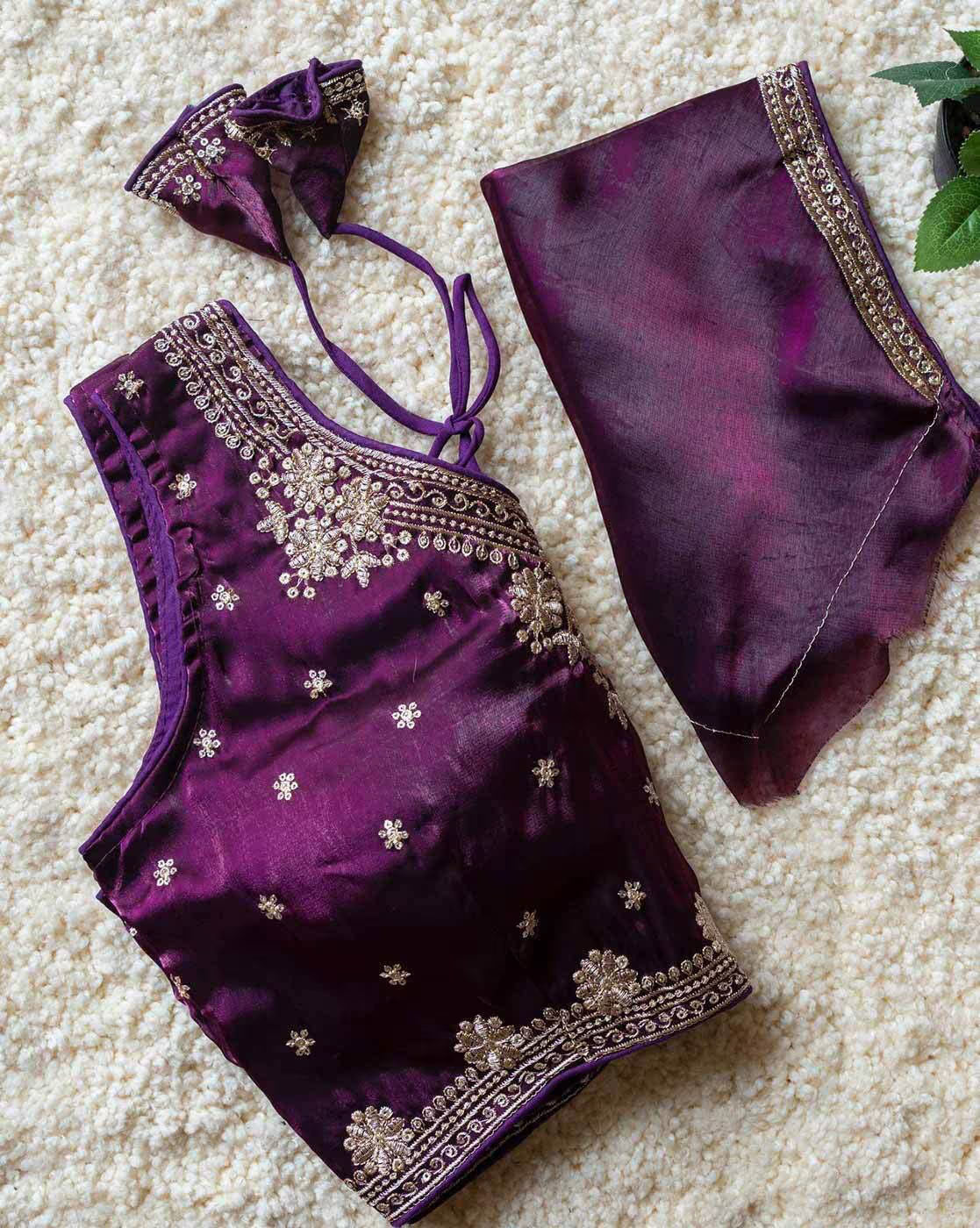 Purple embroidered blouse and pants on a beige carpet
