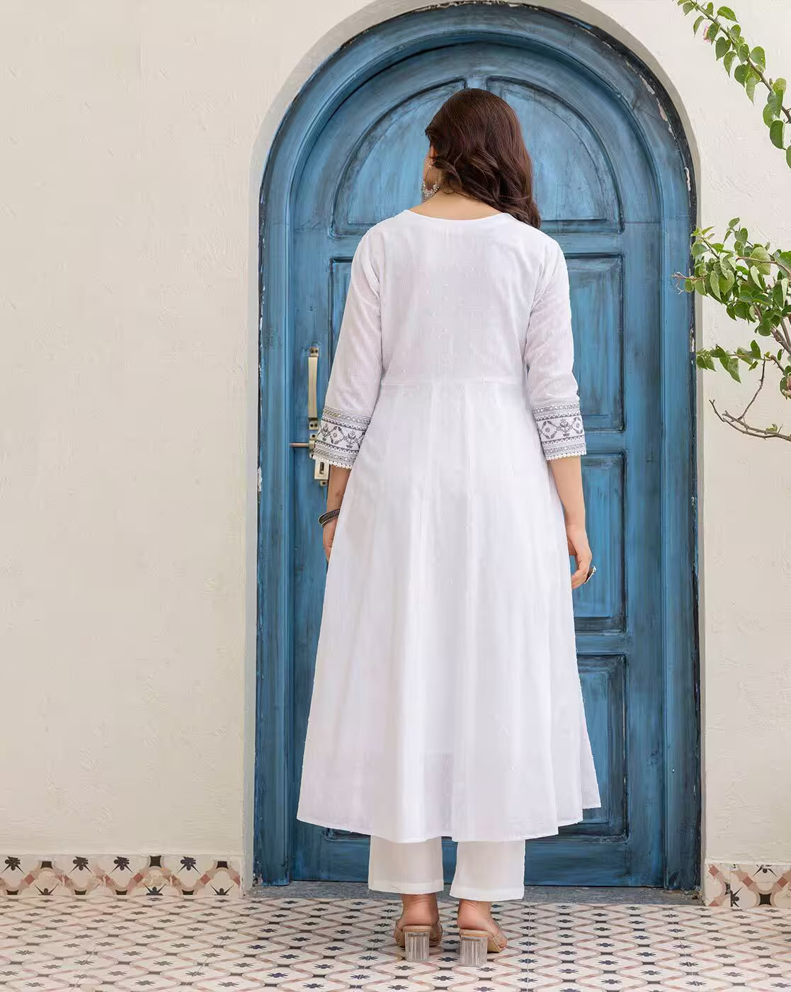 Back view of woman wearing embroidered kurta set for women in white with embroidered sleeve cuffs and straight pants