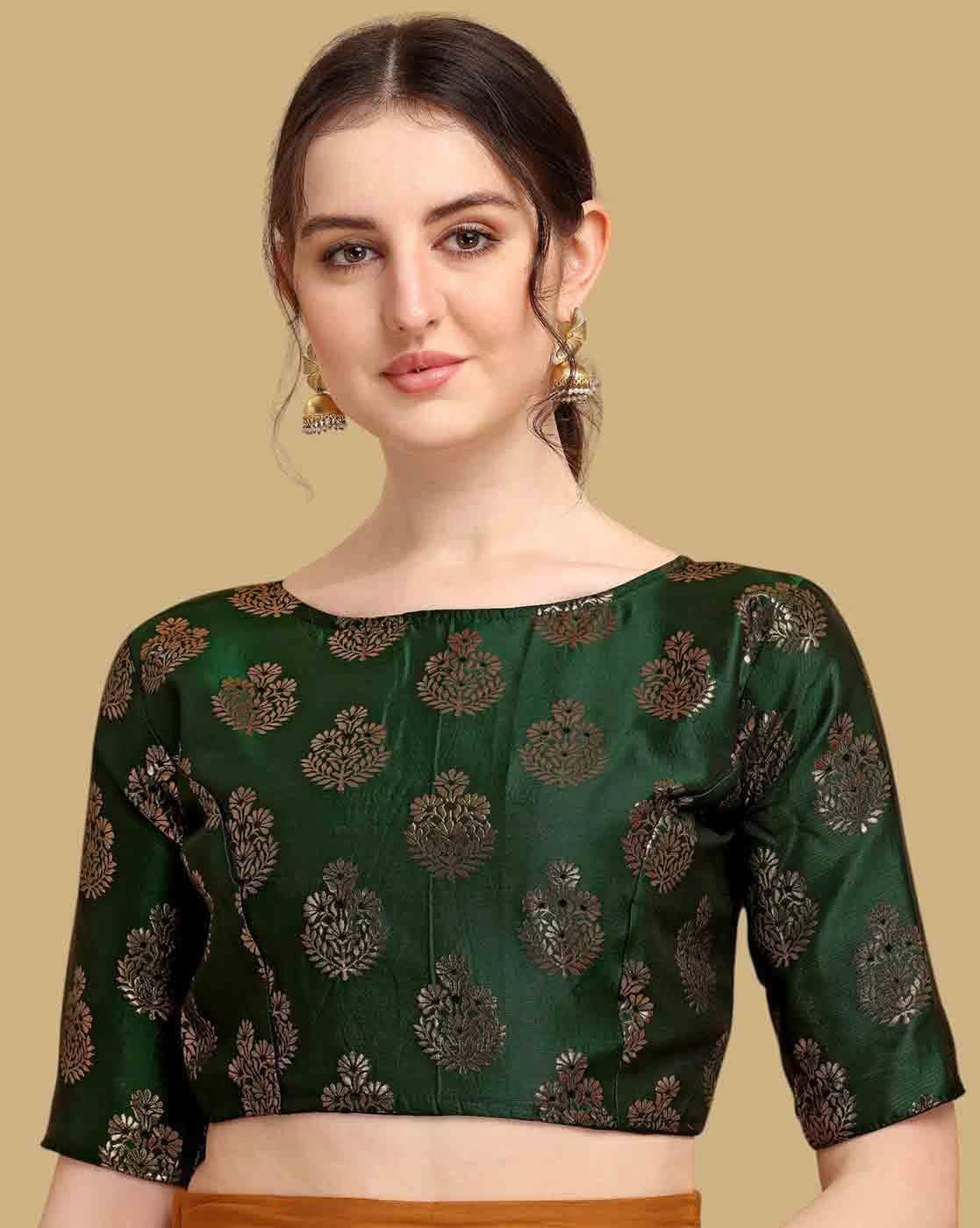 Woman wearing a green blouse with black floral patterns on a beige background