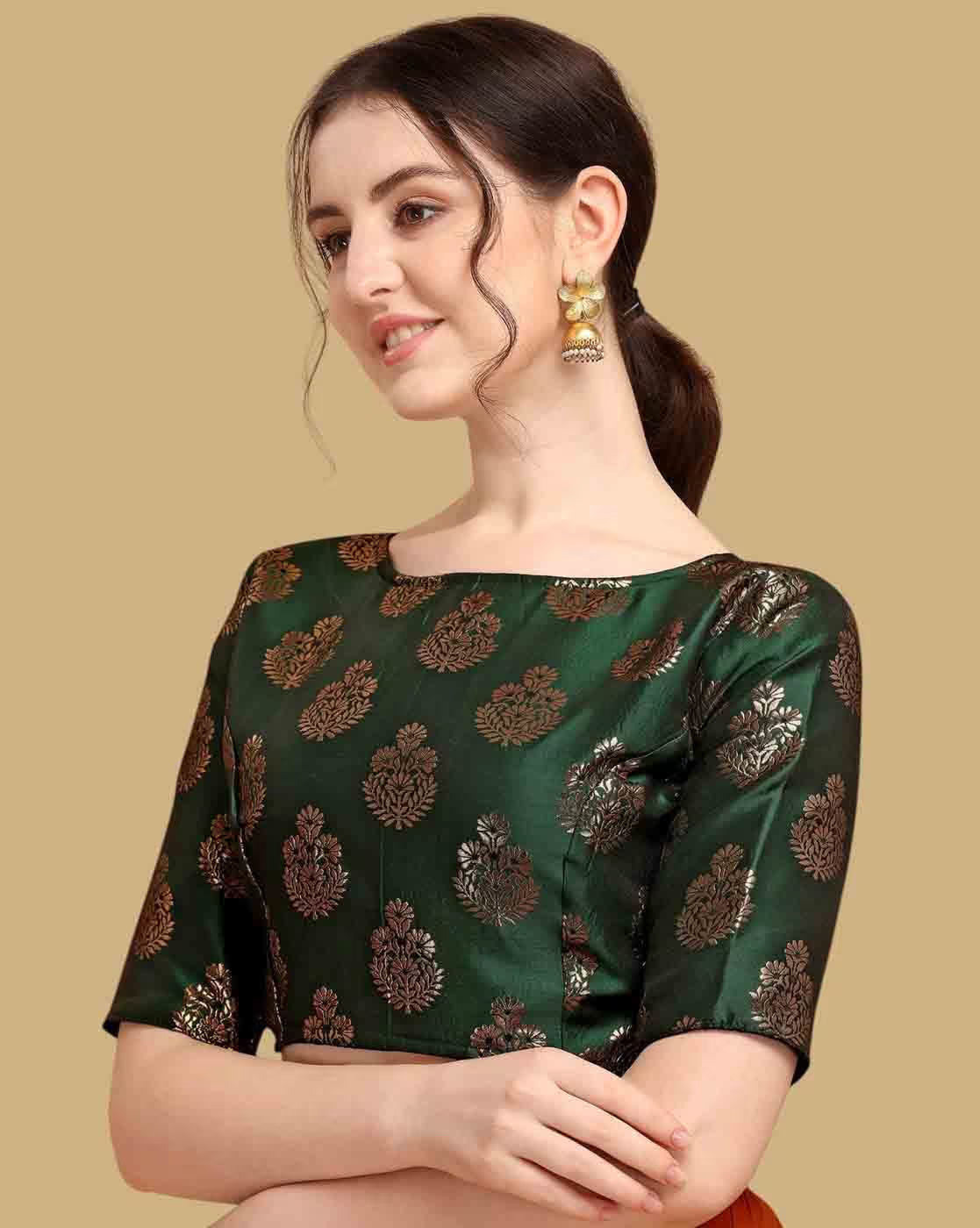 Woman wearing a green blouse with gold patterns on a beige background