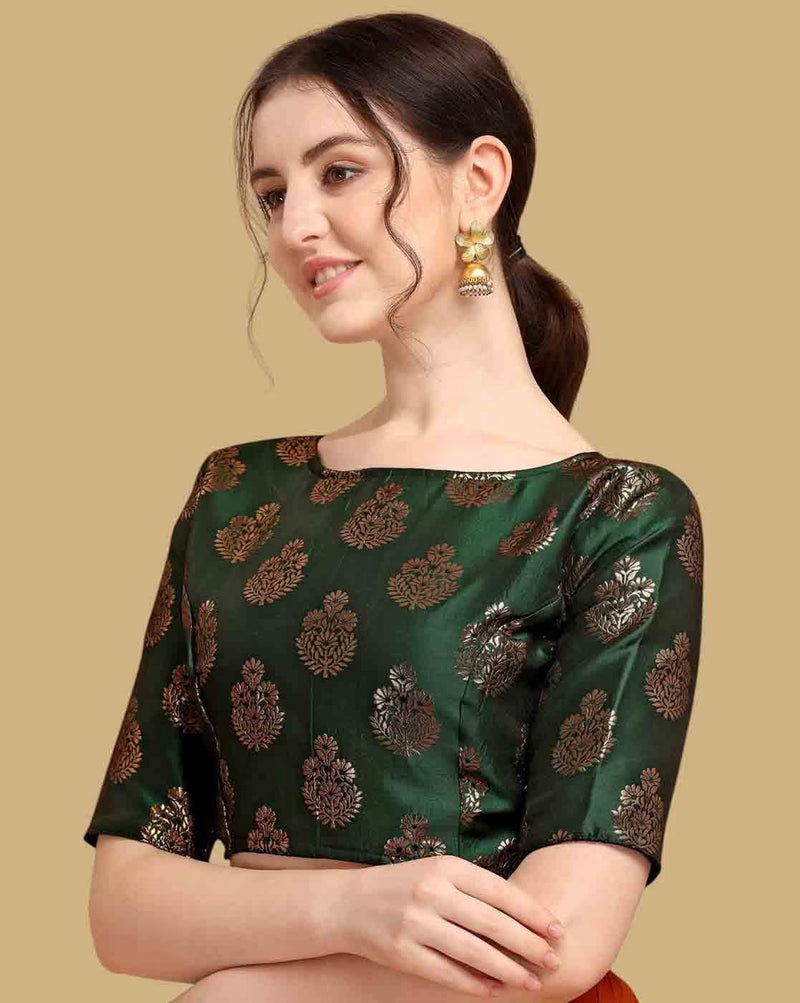 Woman wearing a green blouse with gold patterns on a beige background