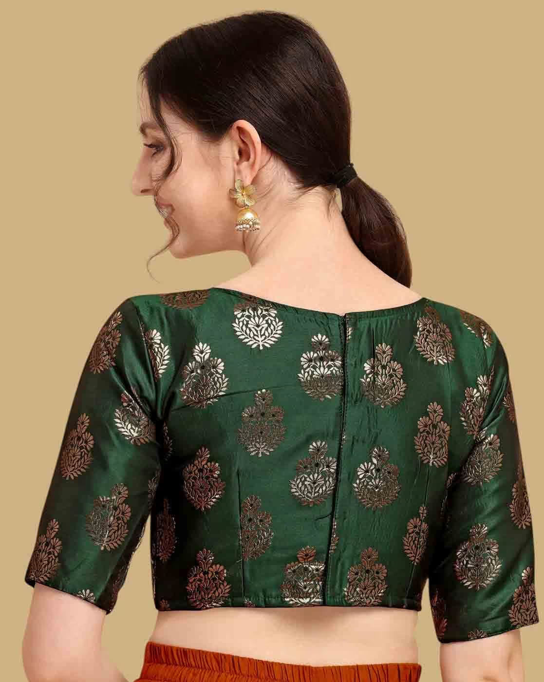 Woman wearing a green blouse with intricate patterns on a beige background