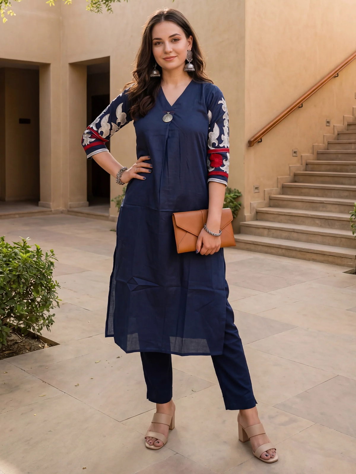 Woman in a navy blue outfit with floral sleeves standing outdoors.