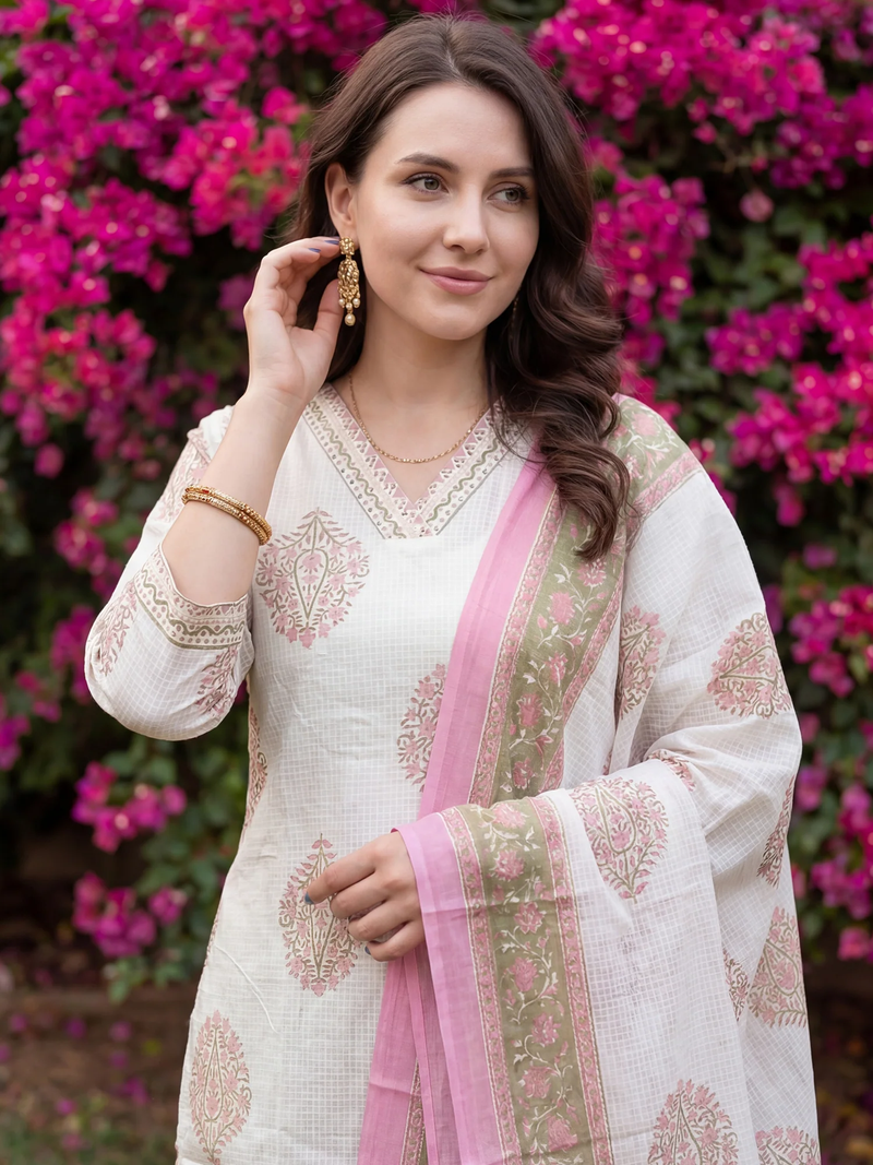 Woman in traditional outfit with pink dupatta against a floral background