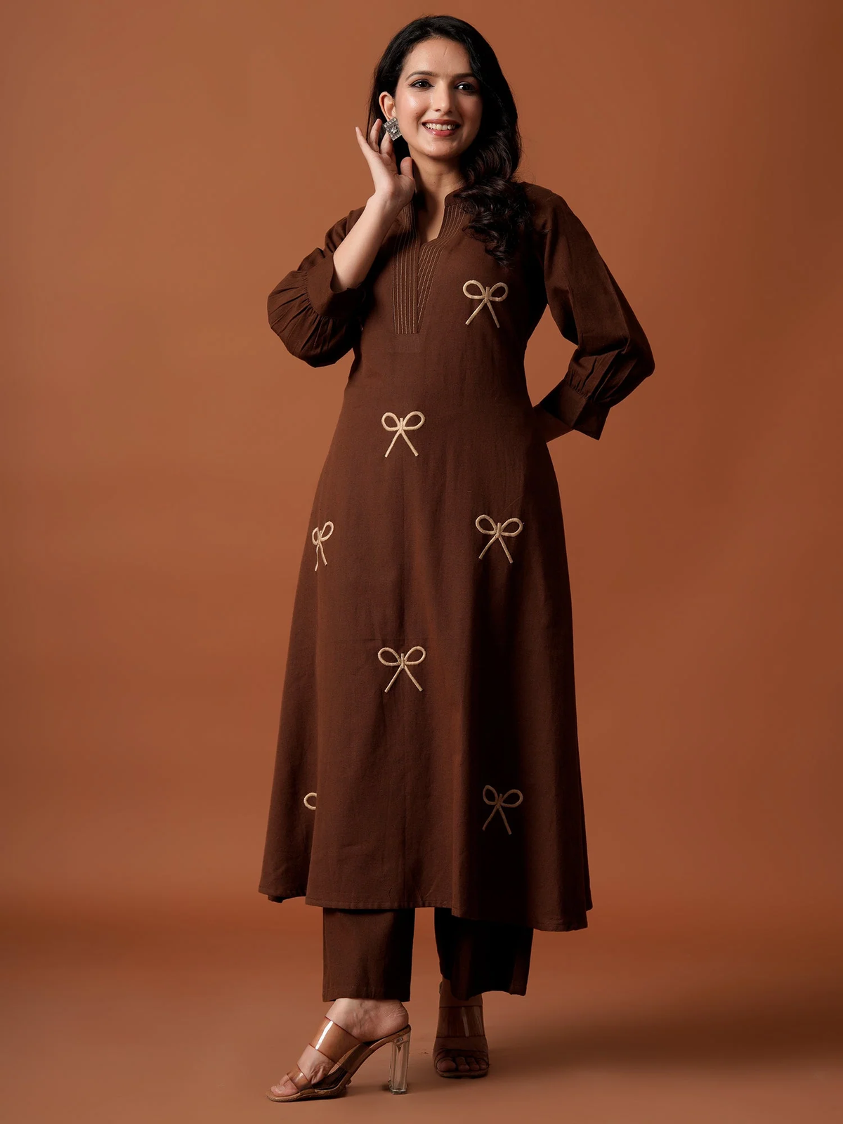 Woman wearing a brown kurta with bow details on a brown background