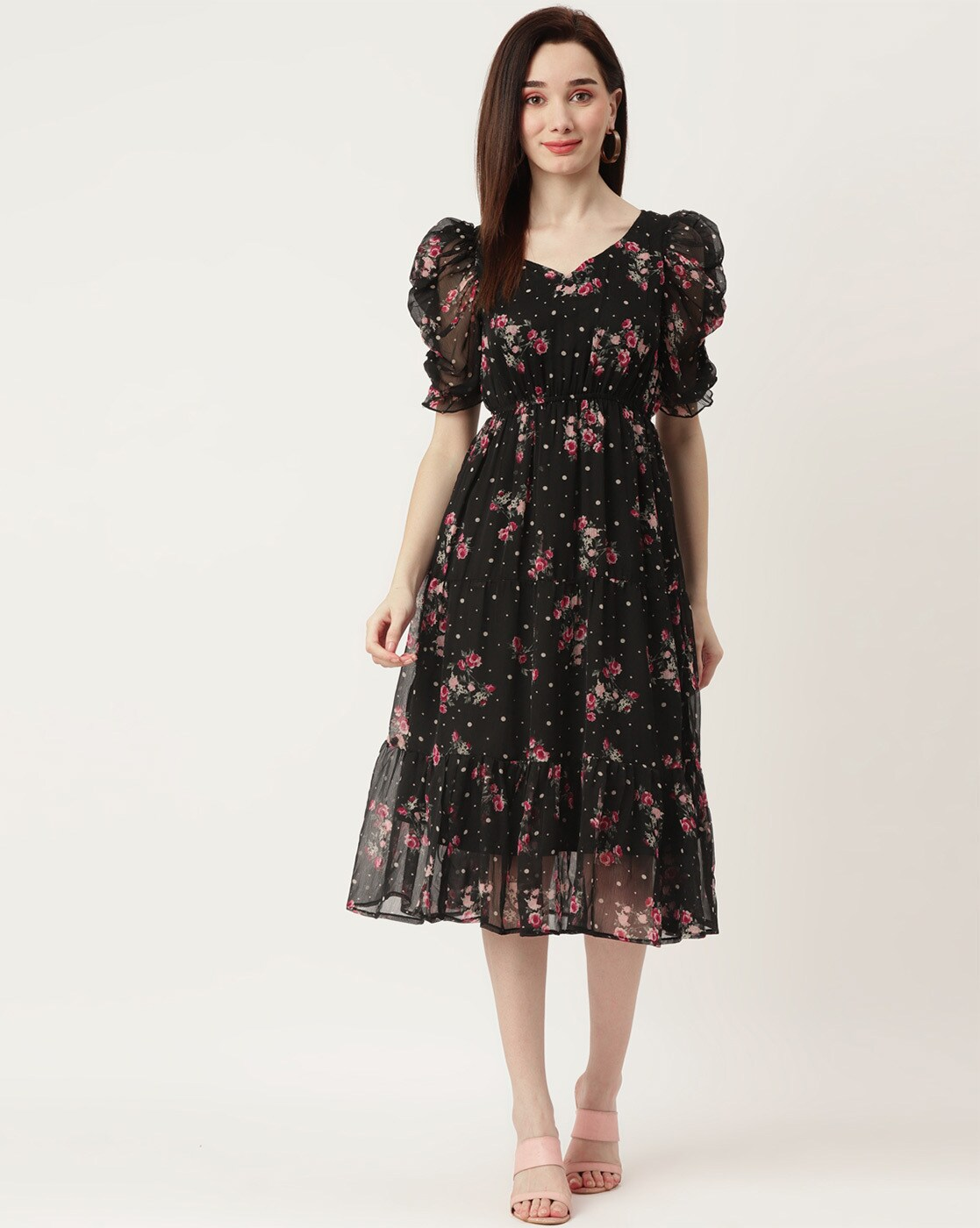 Woman wearing a black floral georgette wrap dress with puff sleeves and V-neck – lined fit & flare style for casual or party wear.