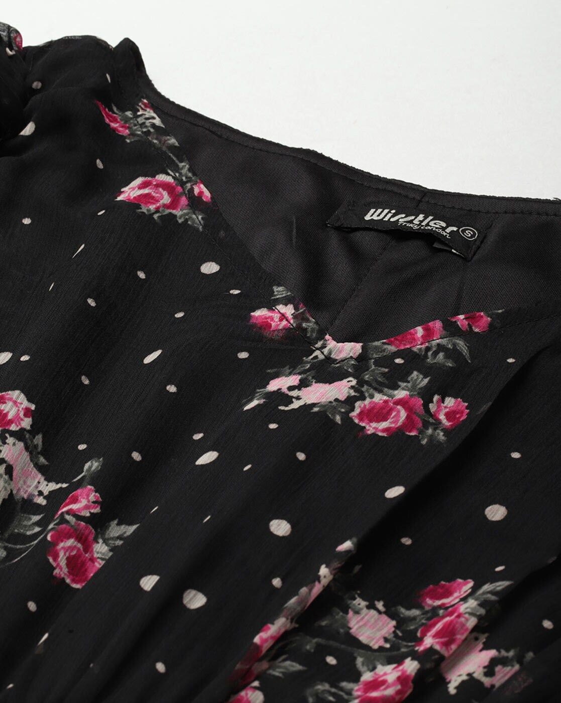 Woman wearing a black floral georgette wrap dress with puff sleeves and V-neck – lined fit & flare style for casual or party wear.