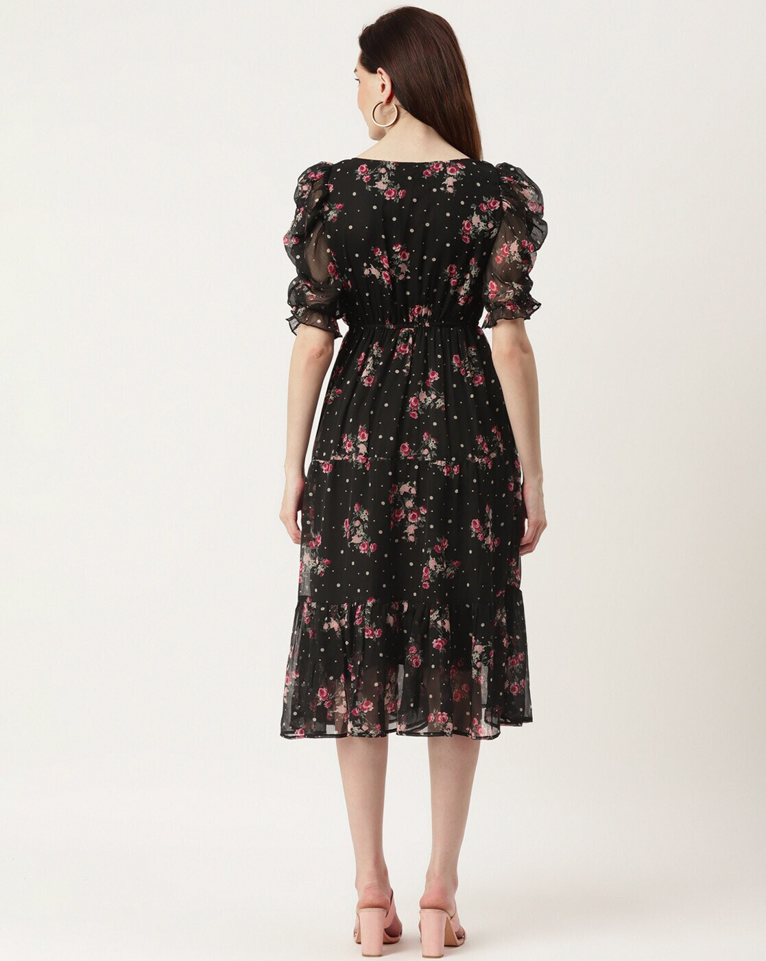 Woman wearing a black floral georgette wrap dress with puff sleeves and V-neck – lined fit & flare style for casual or party wear.