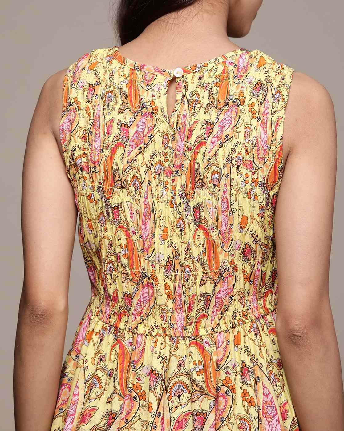 Woman wearing a paisley print sleeveless fit & flare rayon dress with round neckline – classic and lightweight casual wear.