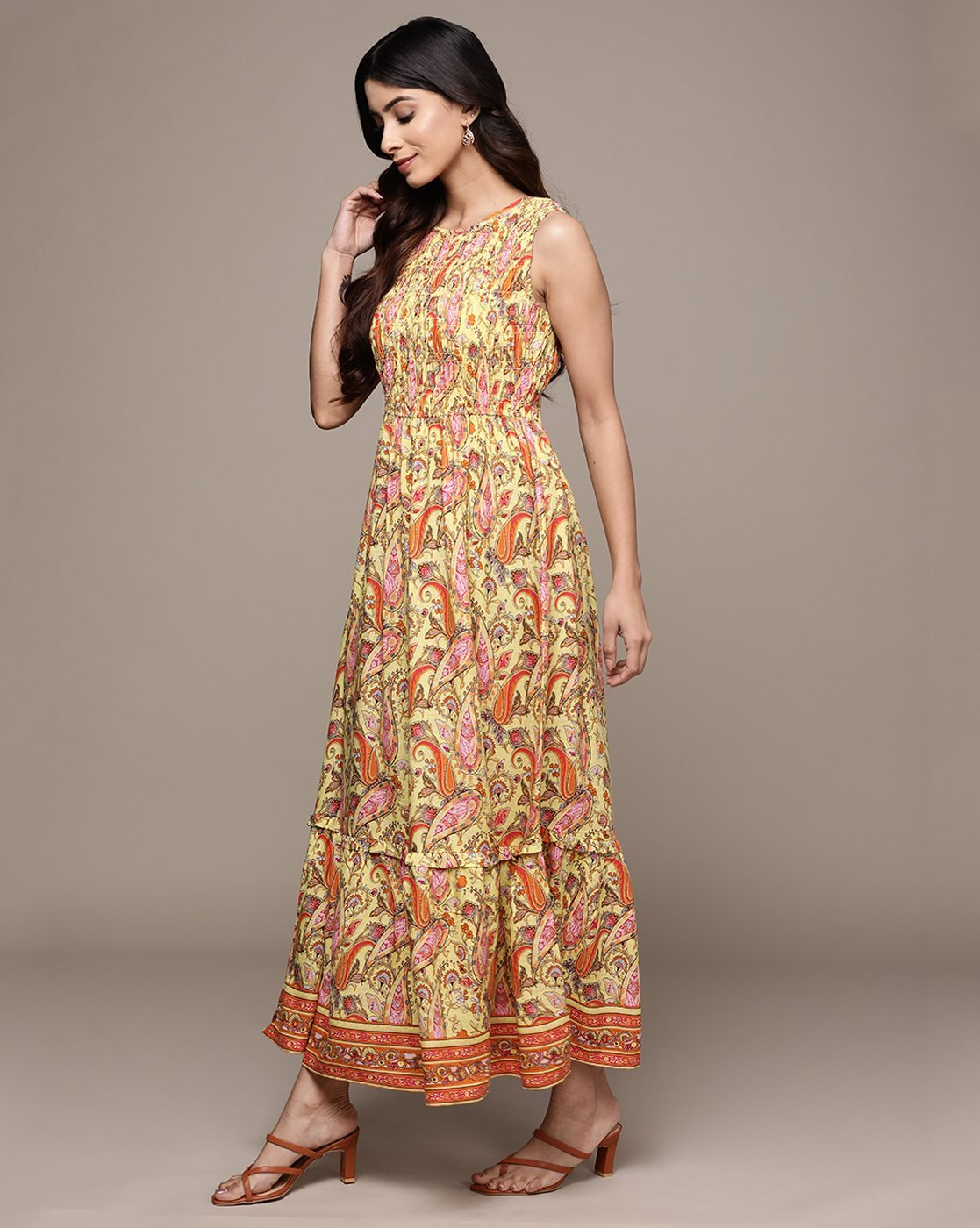 Woman wearing a paisley print sleeveless fit & flare rayon dress with round neckline – classic and lightweight casual wear.