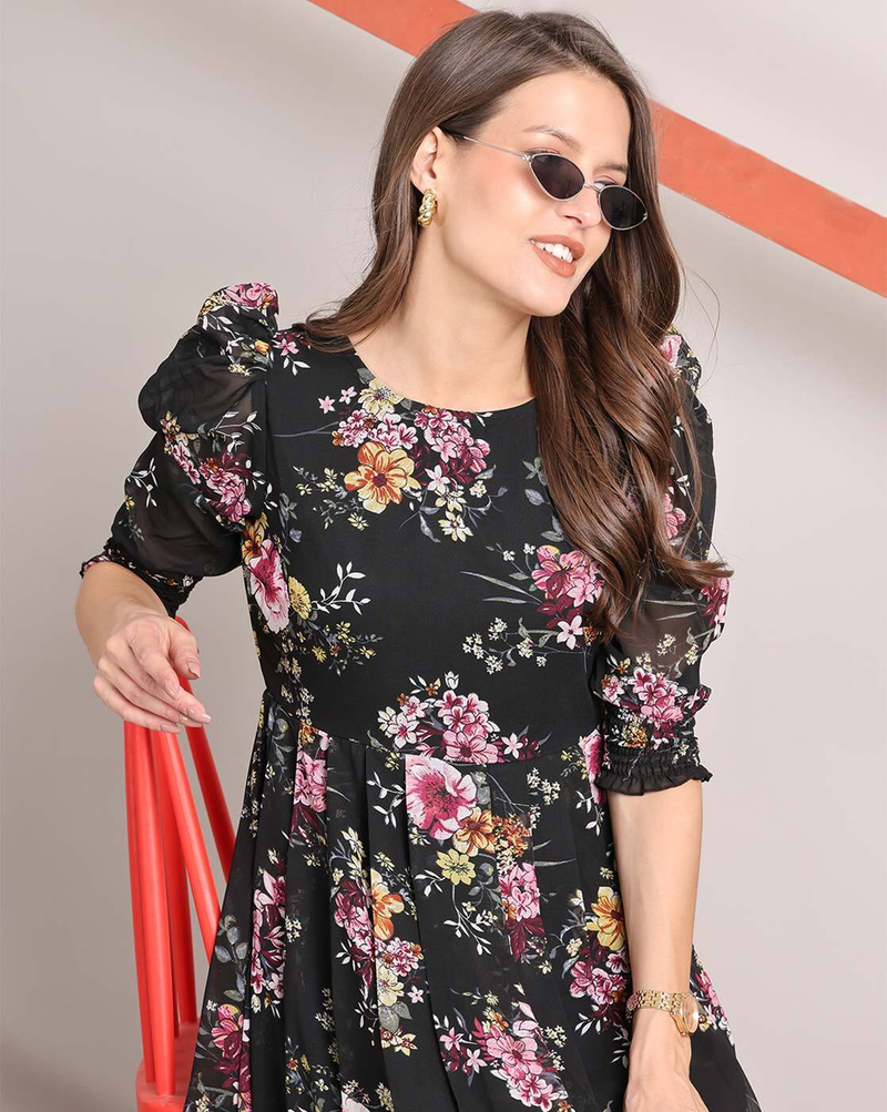 Woman wearing a handcrafted floral smocked tiered georgette dress with round neckline and stylised sleeves – playful and elegant casual wear.