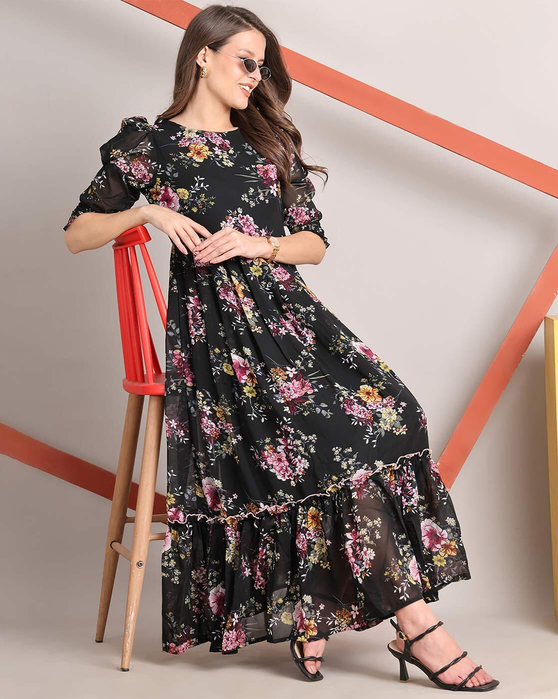 Woman wearing a handcrafted floral smocked tiered georgette dress with round neckline and stylised sleeves – playful and elegant casual wear.