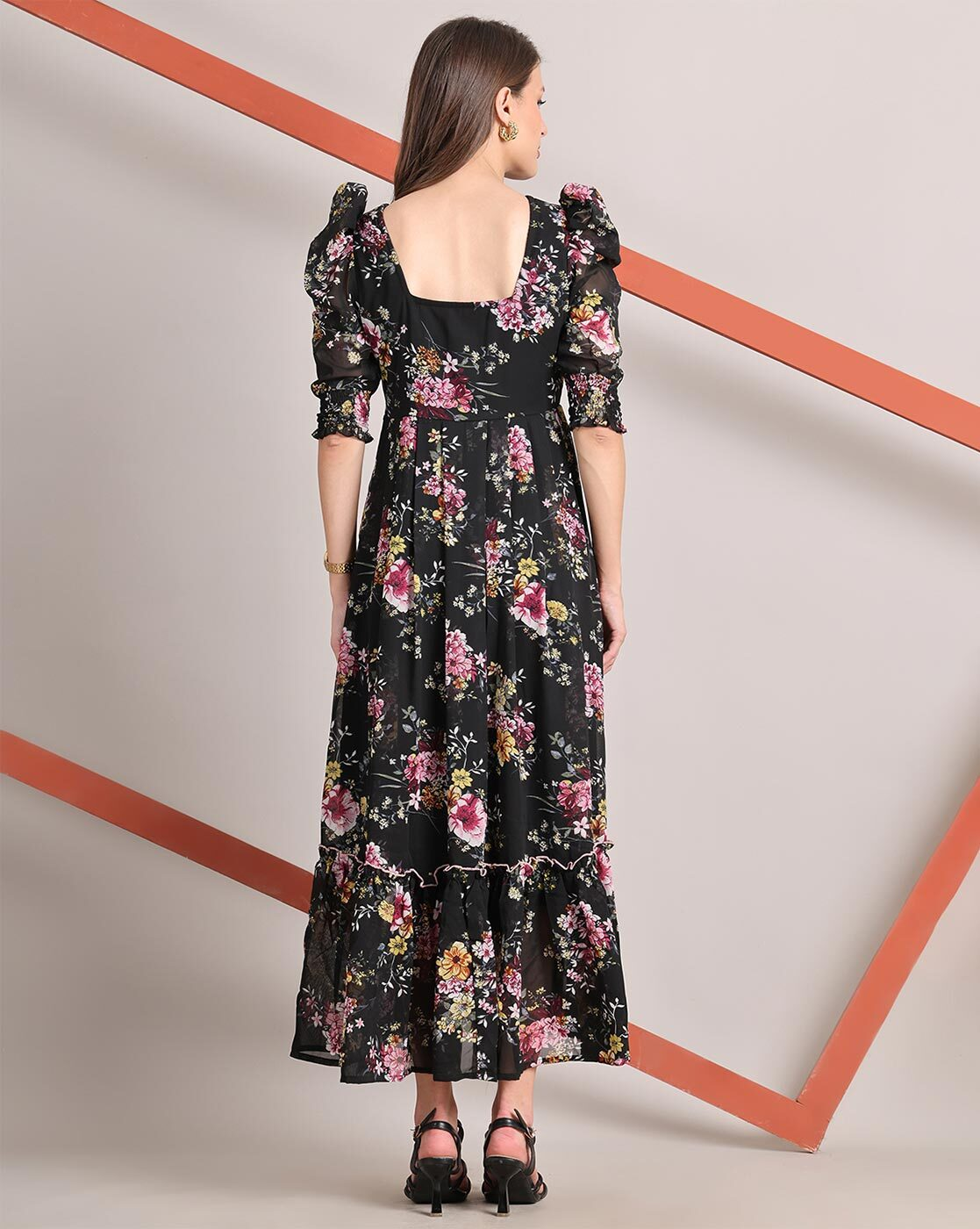 Woman wearing a handcrafted floral smocked tiered georgette dress with round neckline and stylised sleeves – playful and elegant casual wear.