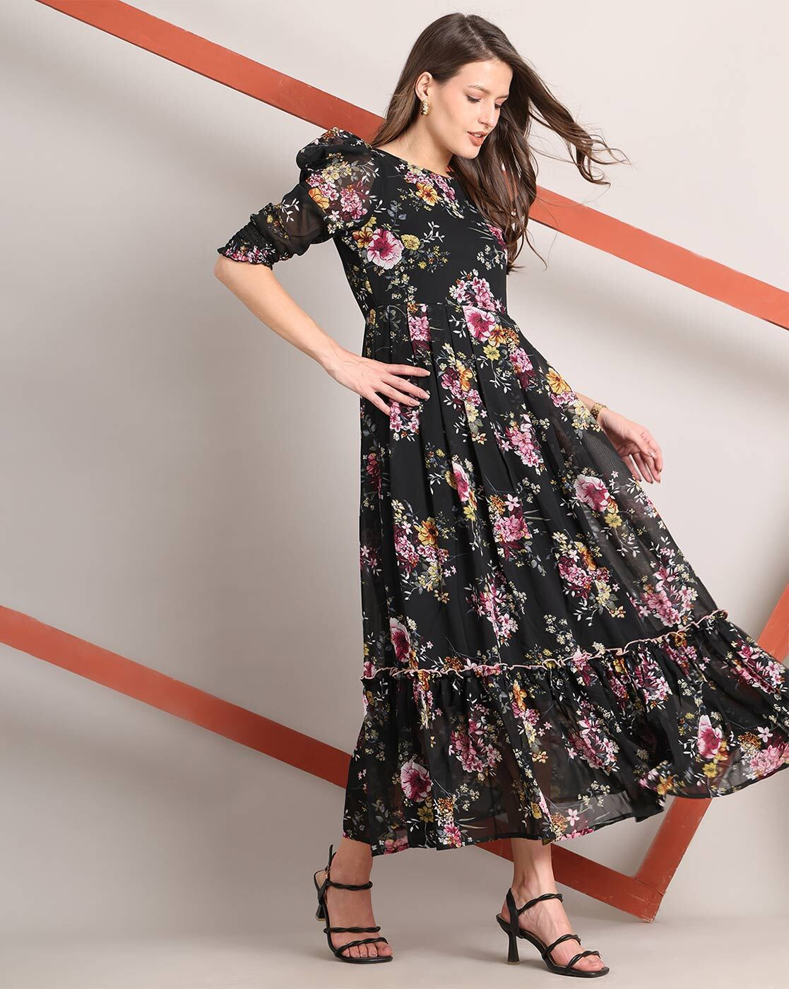 Woman wearing a handcrafted floral smocked tiered georgette dress with round neckline and stylised sleeves – playful and elegant casual wear.