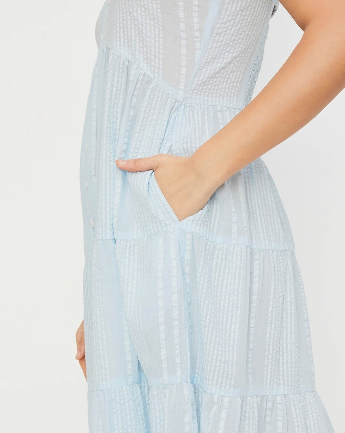 Woman wearing a 100% cotton seersucker tiered dress with round neckline – casual and lightweight for everyday summer wear.