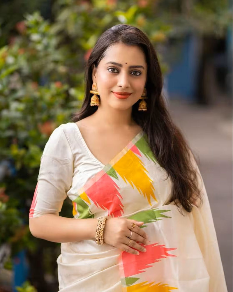 Aromie affordable silk saree Canada featuring a white saree with colorful geometric patterns worn by a woman with gold jewelry