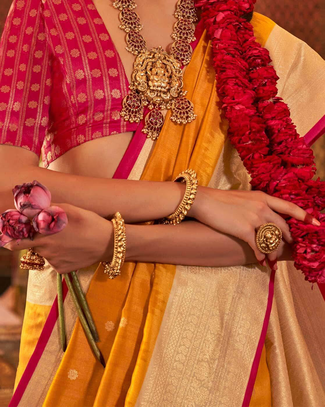 Elegant affordable woven silk saree in gold and pink, paired with ornate jewelry and floral accents