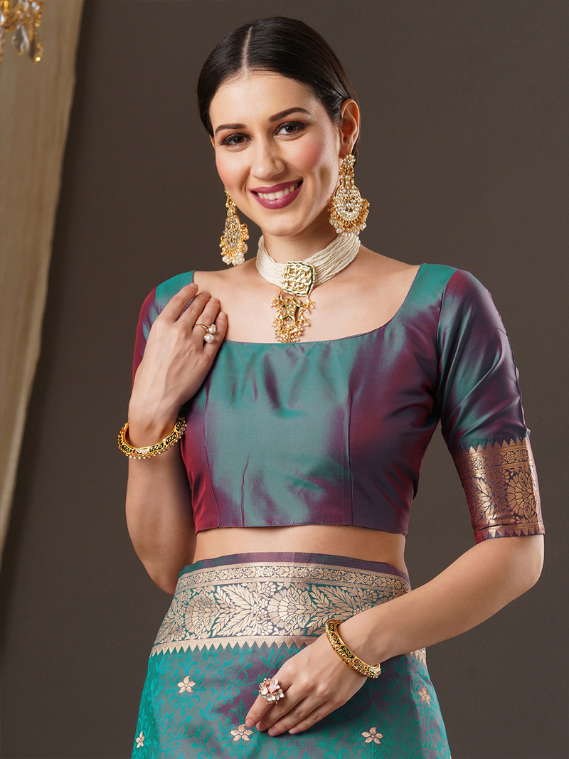 Front view of a woman in a teal and maroon silk party wear Banarasi saree Canada with intricate gold detailing