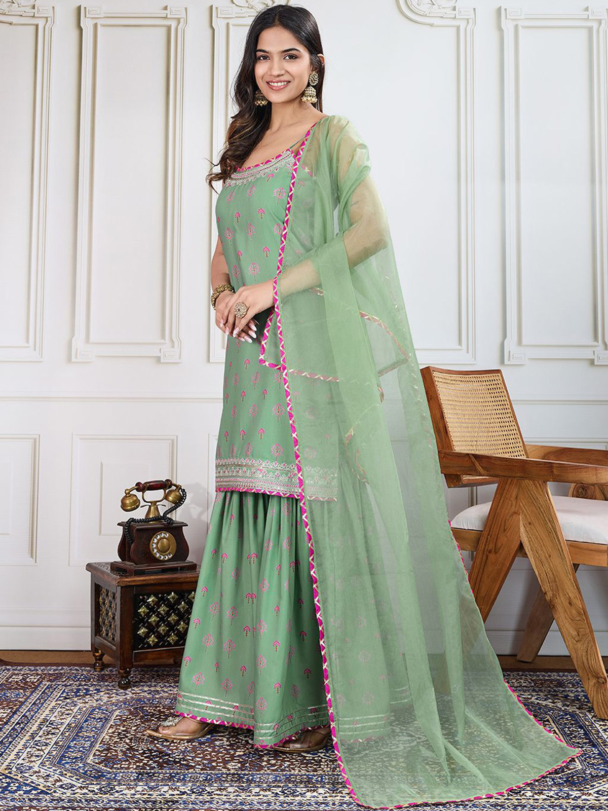 Elegant green three piece Kurtha set with pink accents and embellished details