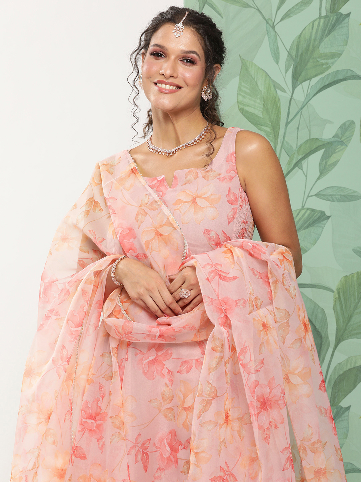 aromie three piece embroidered cotton kurta set in peach floral print with dupatta modeled by smiling woman