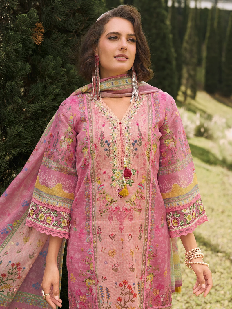 Woman wearing a pink embroidered traditional outfit with a matching dupatta in an outdoor setting.